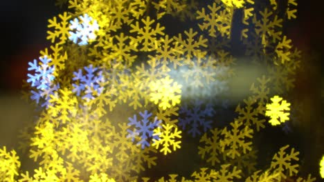 Blue-yellow-flickering-snowflake-light-in-blur-bokeh